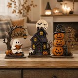 The Boo Crew Halloween decor set styled on a living room coffee table, with a full moon backdrop and cozy plaid throw in the background.